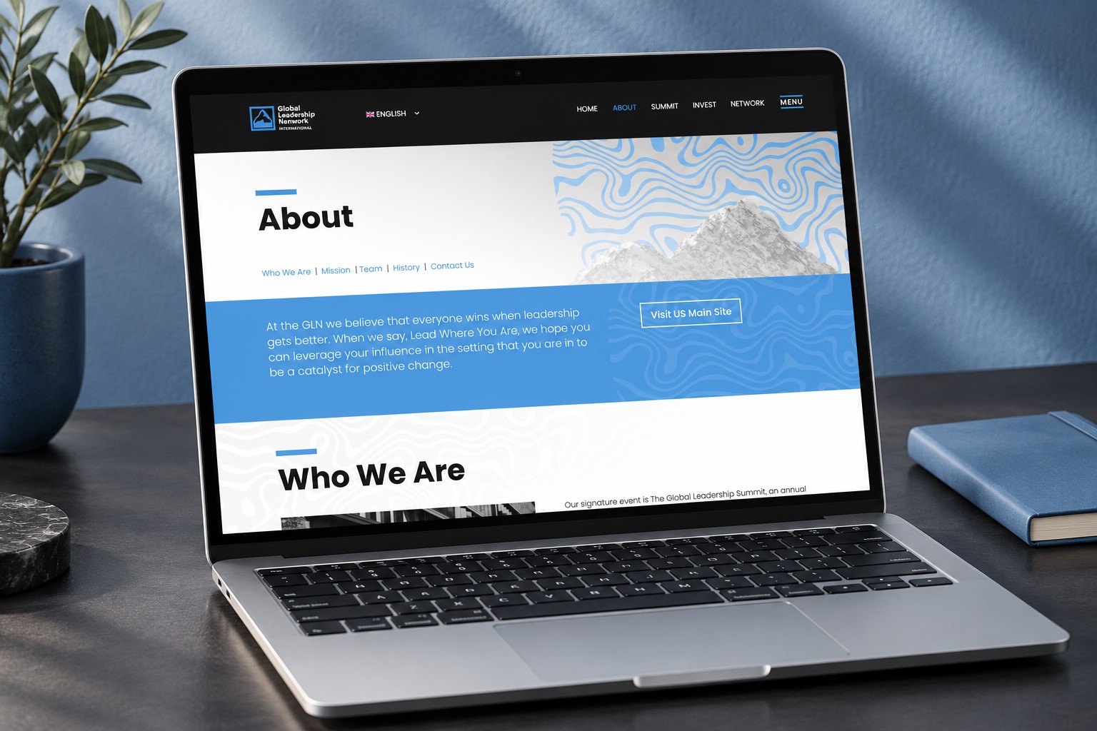 GLNI About page displayed on a silver laptop in a blue-and-charcoal workspace concept