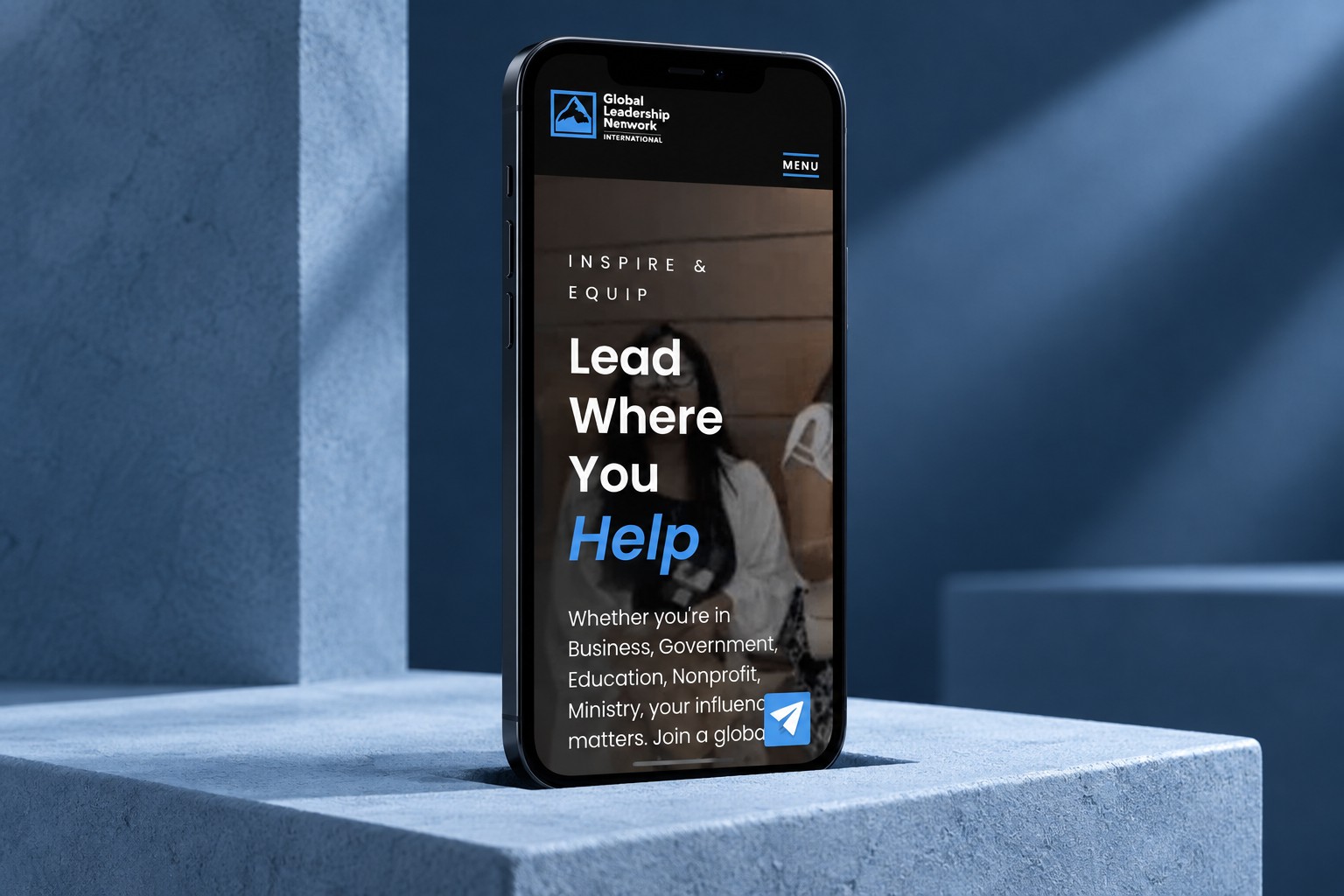 GLNI mobile homepage on a black phone in a blue studio concept